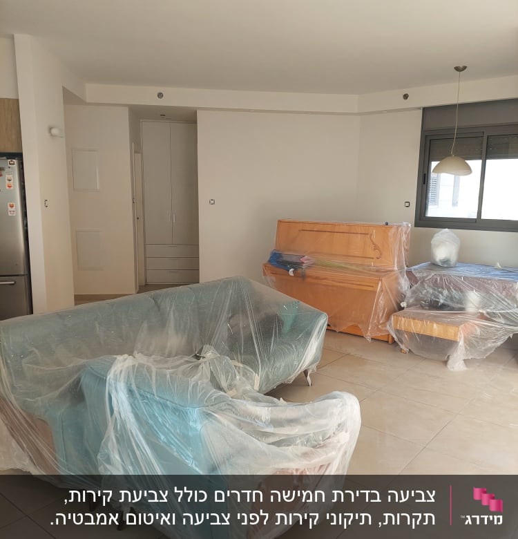 ריהוט מכוסה בניילון לקראת צביעה בחדר